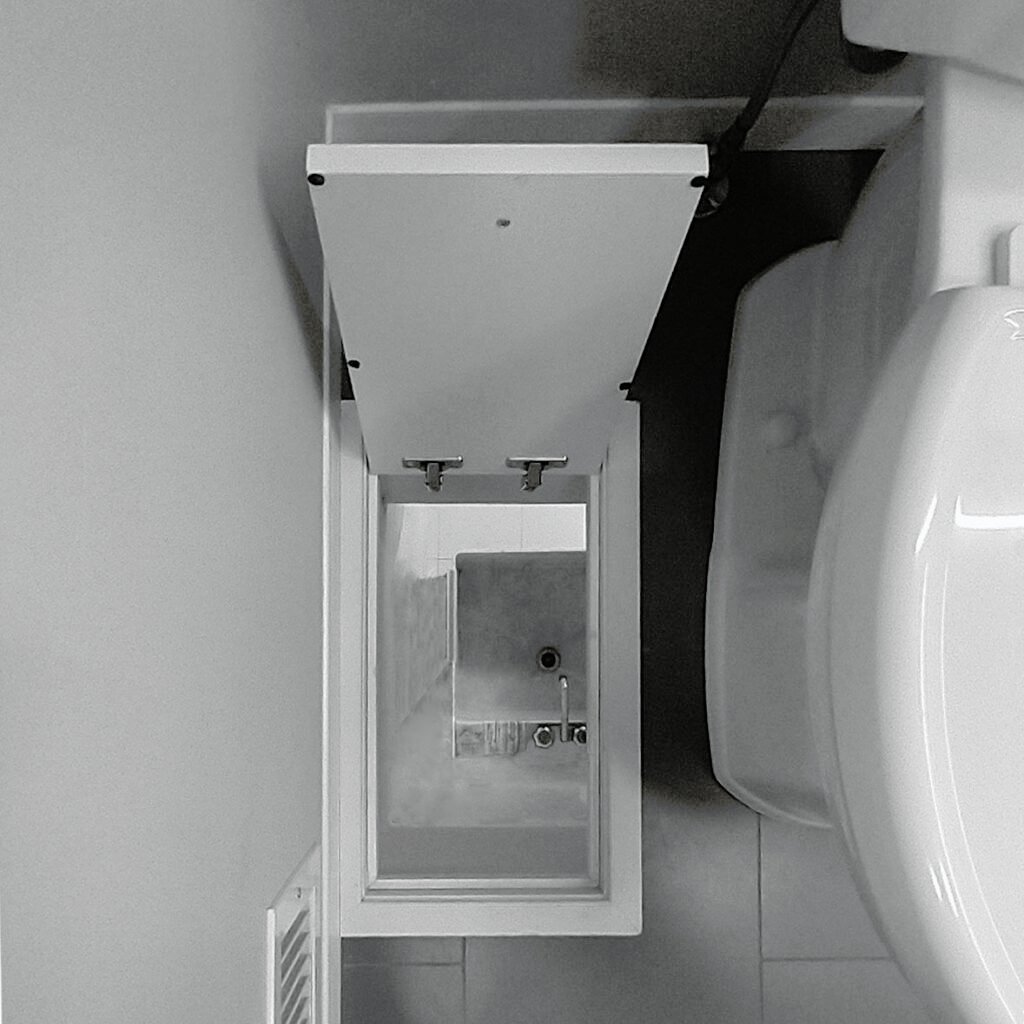 laundry hatch in bathroom floor, laundry tub directly below on floor below